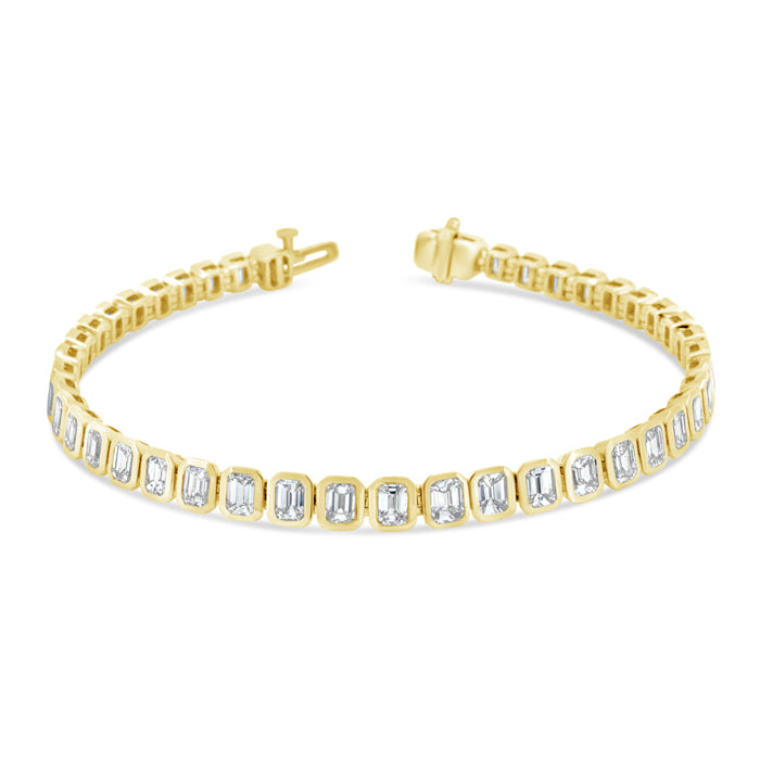 A gold-colored bracelet featuring a series of emerald-cut stones, with metallic clasp fastenings at the ends.