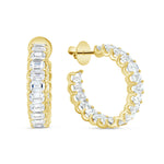 A pair of 18K gold emerald cut hoop earrings with diamonds set in them.