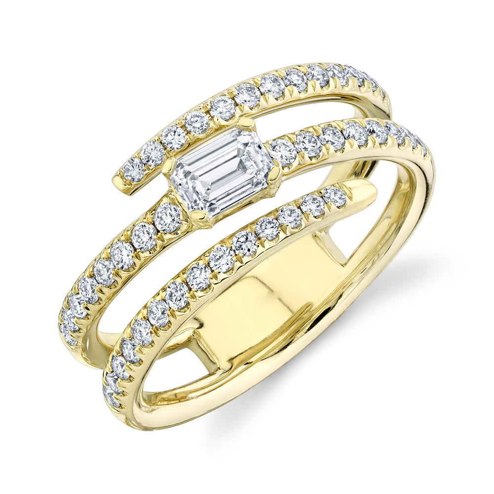A gold wrap ring with emerald cut center stone and pavé bands set with diamonds.