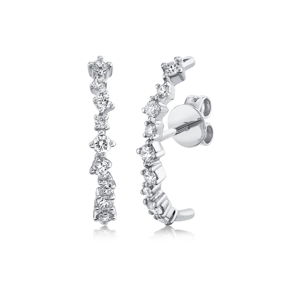 A pair of diamond lobe cuff earrings with 14K metal bands and multiple diamond encrusted settings.