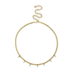 A gold-colored necklace with pear shape diamond accents on a chain.