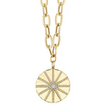 A gold-colored necklace with a paper clip chain design and a round pendant featuring a sun and star motif adorned with diamonds.