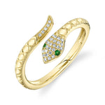 A gold ring featuring a snake-like design with emerald and diamond accents.