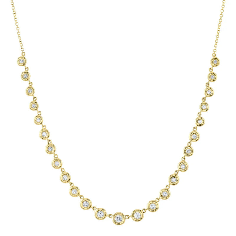 A gold-colored necklace featuring a series of round bezel-set diamonds.