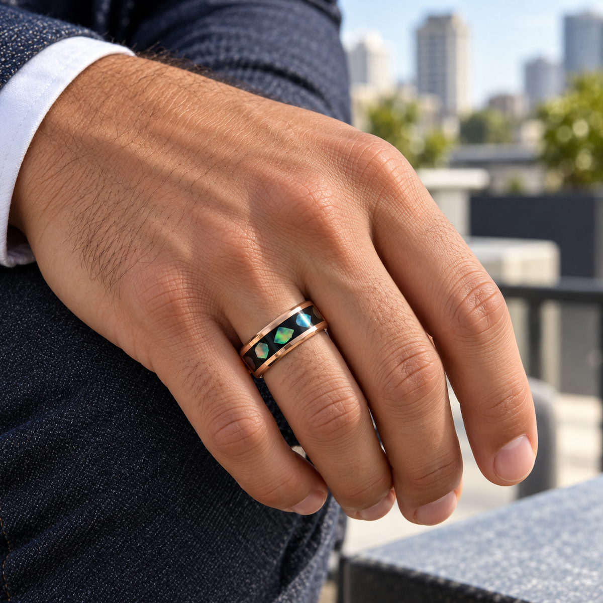 8mm rose tungsten band with black abalone inlay worn on hand in lifestyle setting